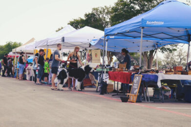 a group of people standing under tents with dogs