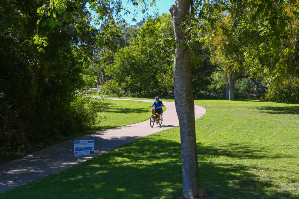 a person riding a bike down a path in the park
