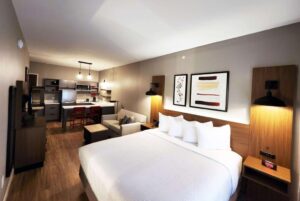 a hotel room with a bed, couch and kitchen